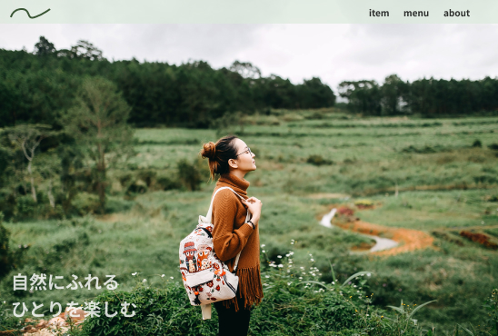 画像：ホームページのファーストビュー、草原で立っているリュックを背負った女性